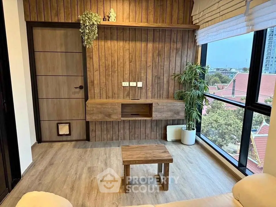 Stylish living room with wooden accents and large windows offering a scenic view.