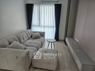 Modern living room with plush gray sofa and natural light