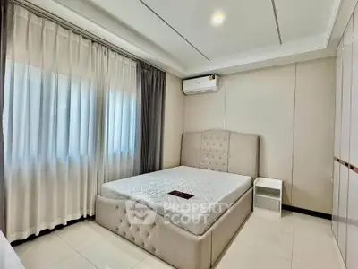 Modern bedroom with elegant design, featuring a plush bed and ample natural light from large windows.