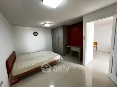 Spacious bedroom with modern minimalist design and ample natural light.