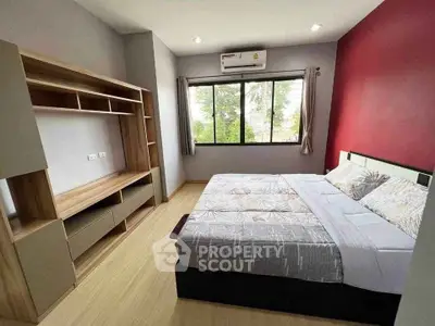 Modern bedroom with stylish furniture and large window offering natural light