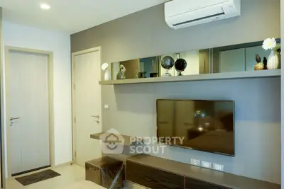 Modern living room with wall-mounted TV and air conditioning in a stylish apartment.