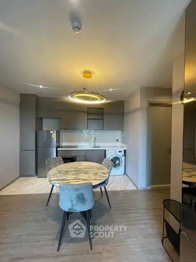 Modern kitchen with open layout, featuring sleek cabinetry, dining area, and integrated appliances.