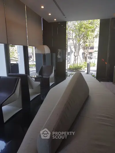 Luxurious modern living room with sleek furniture and large windows offering a serene garden view.