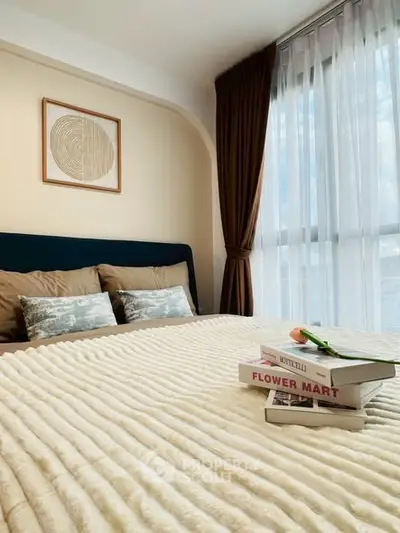 Cozy bedroom with stylish decor and natural light through large window.