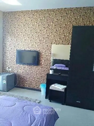Cozy bedroom with modern decor, featuring a wall-mounted TV and stylish furniture.