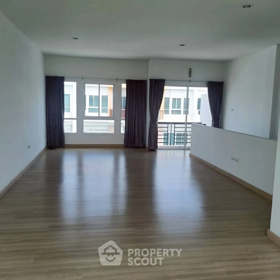 Spacious living room with large windows and balcony access in modern apartment.