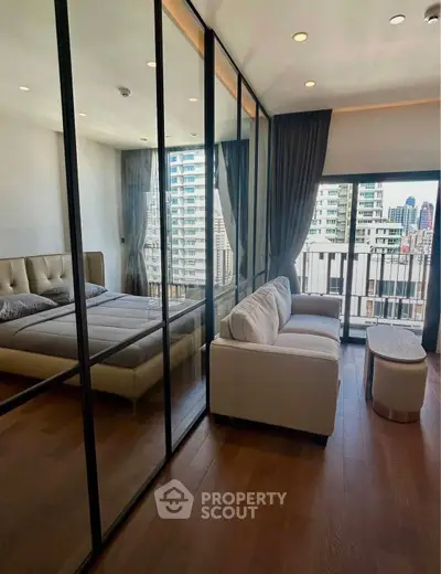 Modern bedroom with glass partition and city view balcony, featuring elegant decor and natural light.