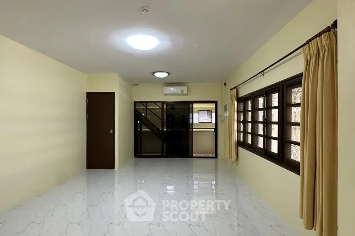 Spacious living room with large windows and modern flooring