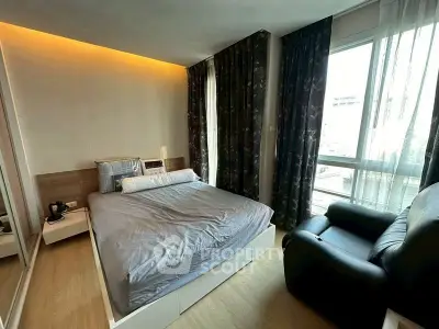 Modern bedroom with large window and cozy furnishings in a stylish apartment.