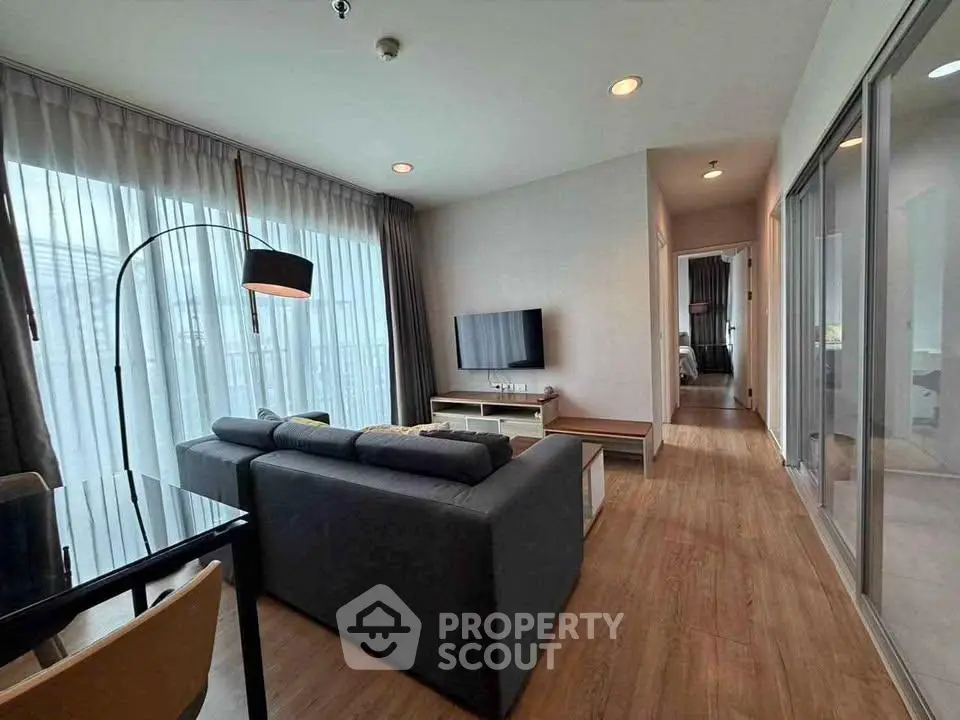 Modern living room with sleek furniture and large windows in a stylish apartment.