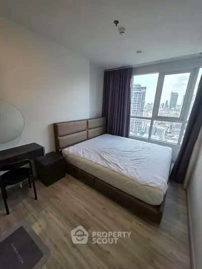 Modern bedroom with city view, featuring a large window, stylish bed, and sleek furniture.