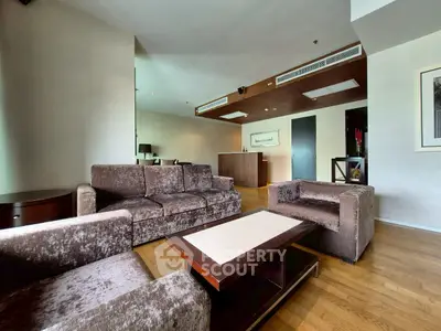 Spacious modern living room with plush seating and elegant wooden accents