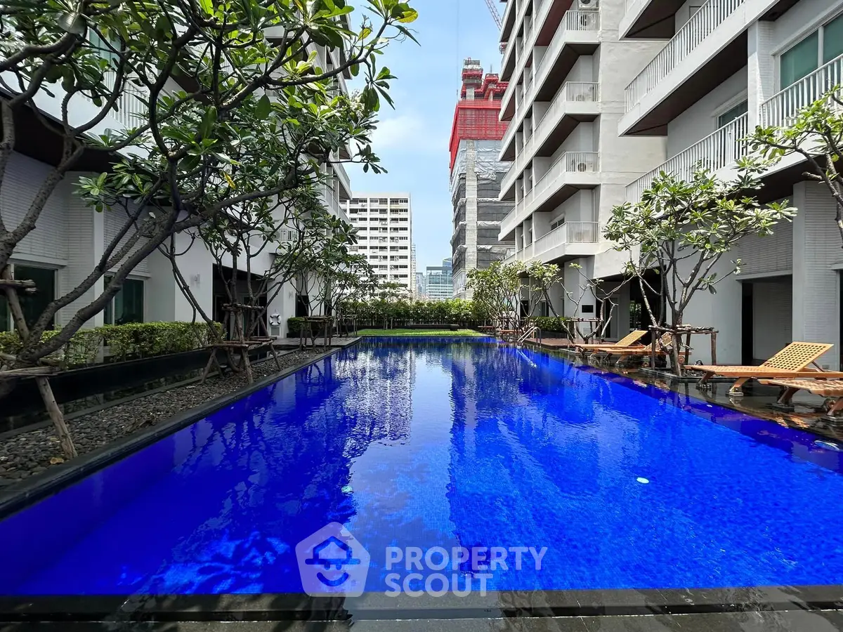 Luxurious residential pool area with modern architecture and lush greenery.