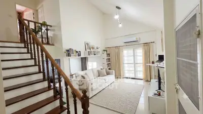 Spacious living room with high ceiling and elegant staircase in modern home