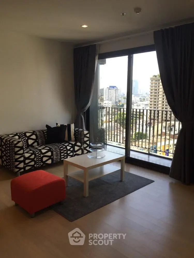 Modern living room with city view and stylish furniture in high-rise apartment.