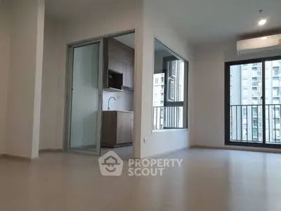 Modern apartment with open layout and balcony view, featuring sleek kitchen design.