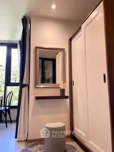 Chic bedroom corner with wardrobe, mirror, and window view in modern apartment.