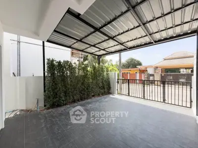 Spacious covered patio with modern design and lush greenery, perfect for outdoor relaxation and entertainment.
