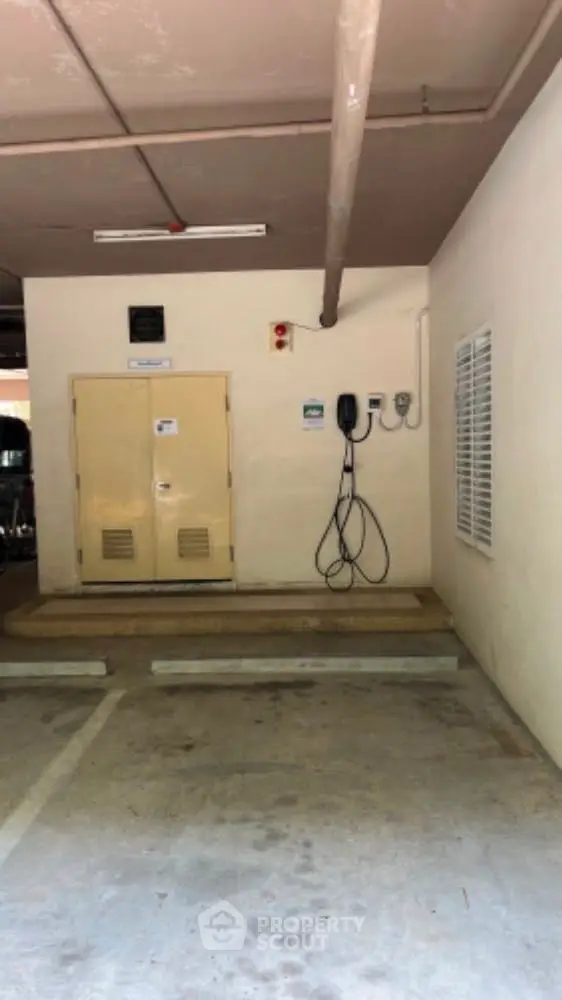 Secure parking space with electric vehicle charging station in modern building.