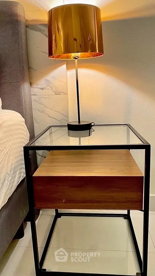 Modern bedroom nightstand with glass top and stylish lamp