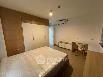 Spacious bedroom with modern wooden furniture and ample storage space