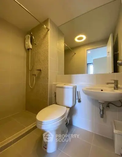 Modern bathroom with shower, toilet, and sink in a sleek, minimalist design.