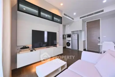 Modern living room with sleek furniture and integrated kitchen appliances in a stylish apartment.