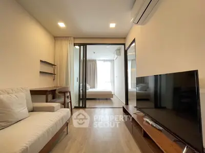 Modern living room with sleek design and natural light, featuring a cozy sofa and flat-screen TV.