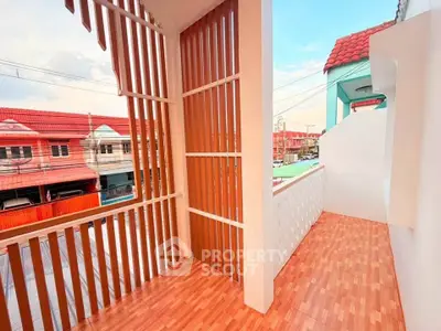 Charming balcony with wooden accents and vibrant neighborhood view, perfect for relaxation and enjoying the outdoors.