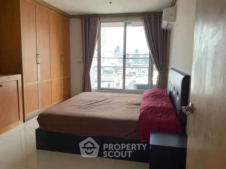 Spacious bedroom with city view and ample storage in modern apartment