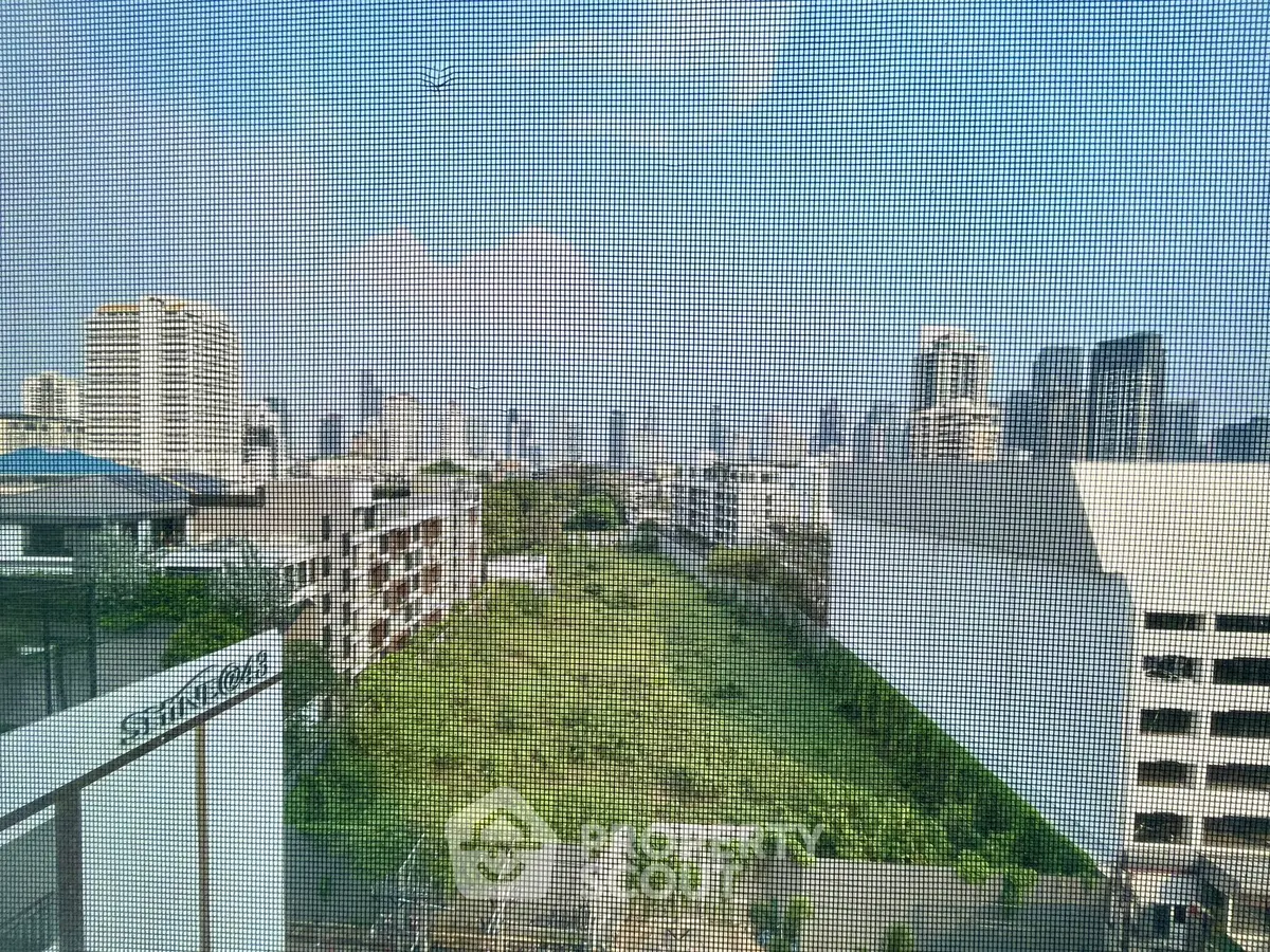 Stunning cityscape view from a high-rise building with lush greenery below, perfect for urban living.