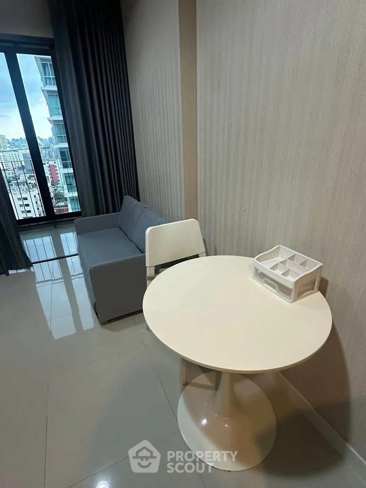Modern living room with city view, featuring sleek furniture and large windows for natural light.