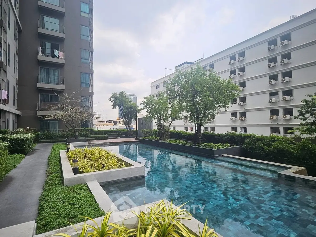 Modern apartment complex with serene pool and lush greenery