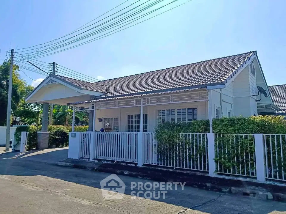 Charming single-story house with tiled roof and fenced yard in a serene neighborhood.