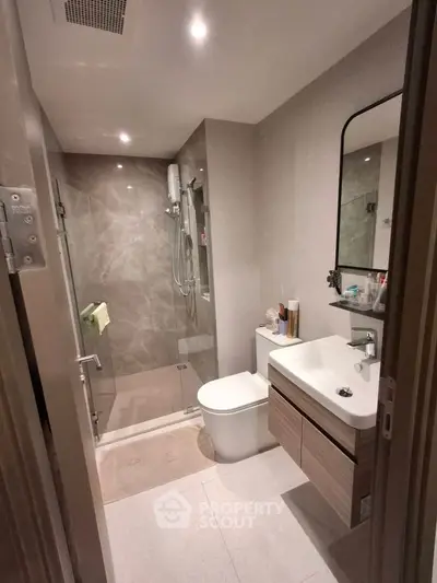 Modern bathroom with sleek fixtures and spacious shower in contemporary apartment.