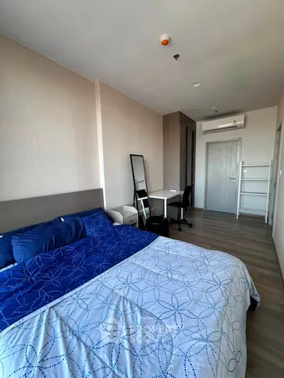 Modern bedroom with stylish decor and workspace in a contemporary apartment.