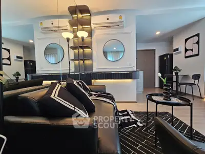 Modern living room with stylish black furniture and geometric decor in a contemporary apartment.