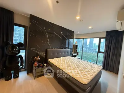 Luxurious bedroom with modern decor and stunning city view, featuring a stylish black accent wall and large windows.