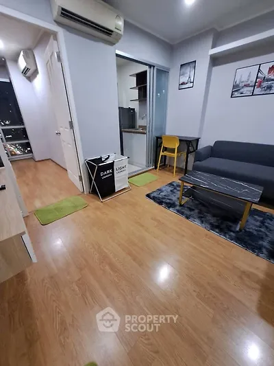 Modern living room with wooden flooring, cozy sofa, and stylish decor in a city apartment.