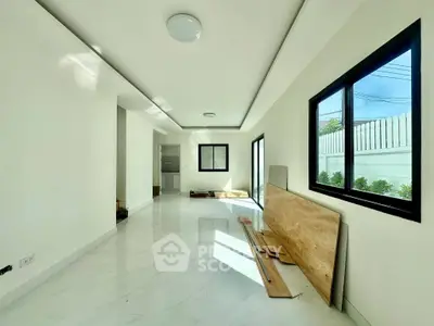 Spacious modern living room with large windows and sleek white flooring