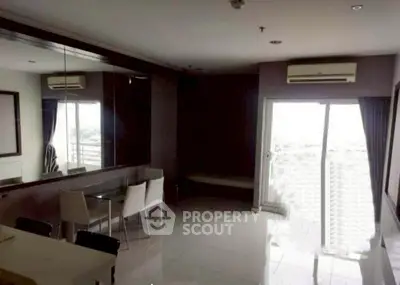 Spacious living room with modern dining set and large windows for natural light.