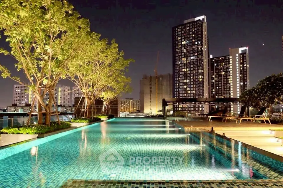 Luxurious rooftop pool with stunning city skyline view at night.