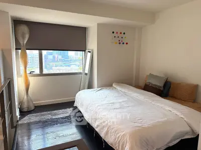 Modern bedroom with city view, featuring sleek decor and ample natural light.