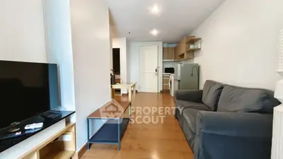 Modern living room with sleek furniture and open kitchen layout in a stylish apartment.