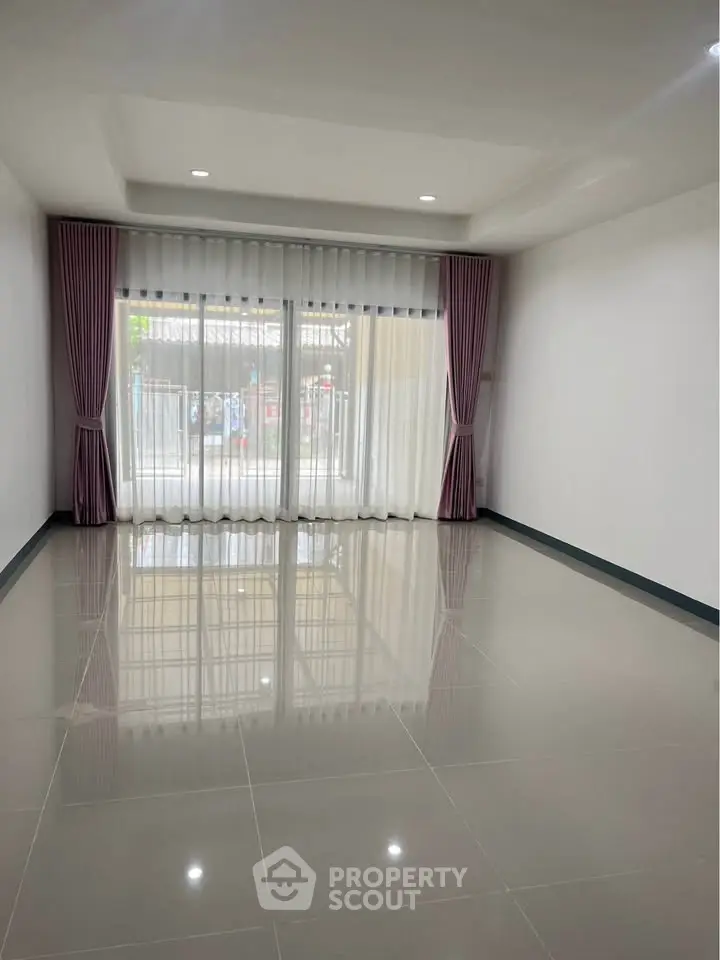 Spacious empty living room with large windows and elegant curtains, perfect for customization.