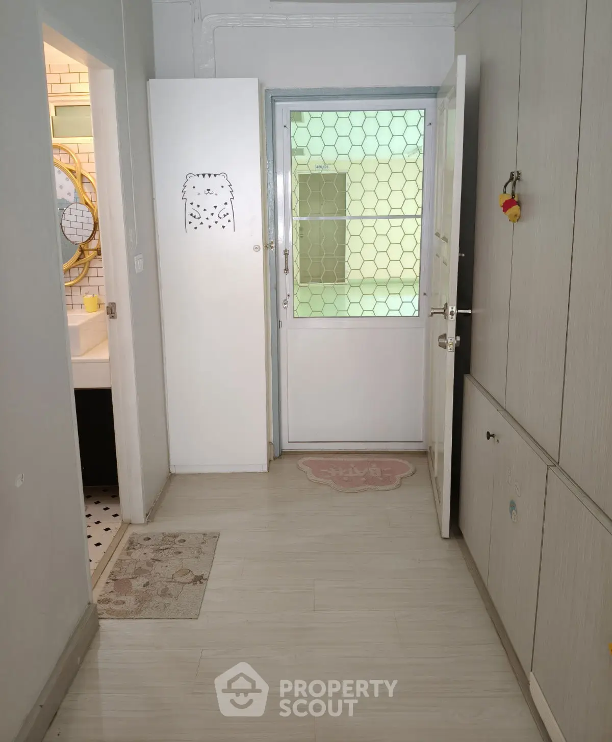 Charming hallway entrance with modern decor and bathroom access, perfect for cozy living.