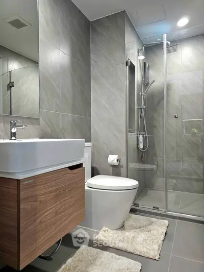 Modern bathroom with sleek design, glass shower, and stylish fixtures in contemporary apartment.