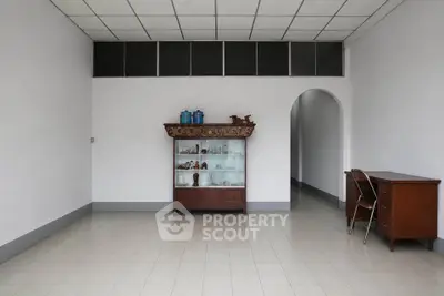 Spacious minimalist room with vintage furniture and tiled flooring