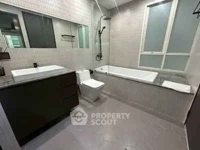 Modern bathroom with sleek fixtures and a spacious bathtub in a contemporary apartment.